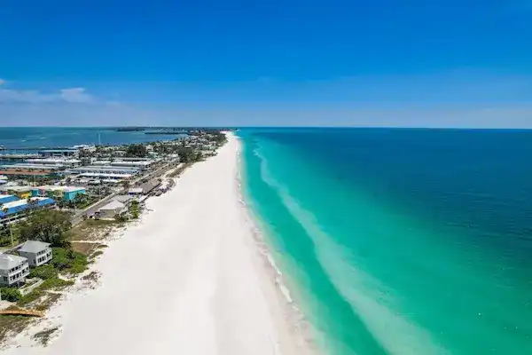 Aerial view of the white sand beach and turquoise ocean water on Anna Maria Island, Florida.